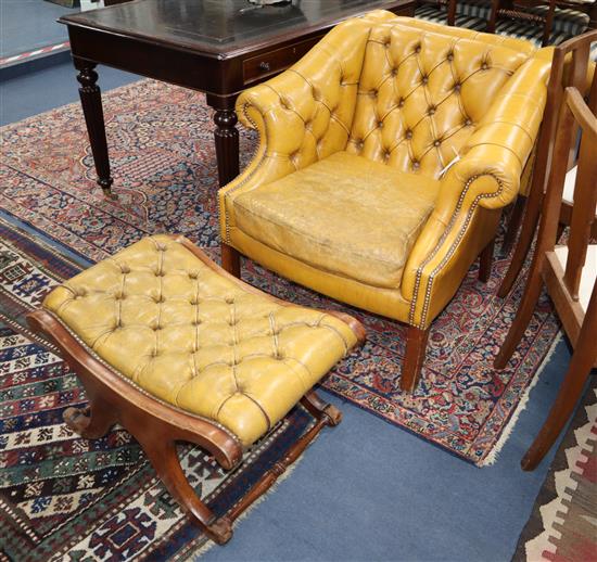 A pair of buttoned pale tan leather library chairs and footstool